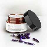 Tribal Marks natural relief magnesium lotion in a 4 oz amber jar,  with lavender flower sprigs in the foreground