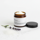 SheaCrafted Natural Relief Magnesium Lotion with lid on the surface and lavender sprig in the foreground