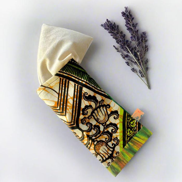 Flatlay of Tribal Marks Bundle of Ankara Herbal Aromatherapy Eye Pillow insert showing out of the pillow cover with a lavender sprig next to it