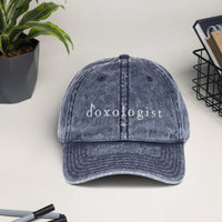 Tribal Marks Doxologist vintage twill cap in navy on a table with a book basket and plant and pens