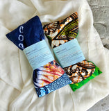 Flatlay of Tribal Marks pair of Ankara Herbal Aromatherapy Eye Pillows on a fabric on a rock