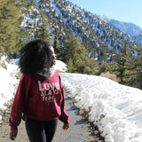 Tribal Marks Beloved Sage Collection Crewneck Sweatshirt saying Love Slays Fear. Repeat. Walking high on a mountain with a snowy view